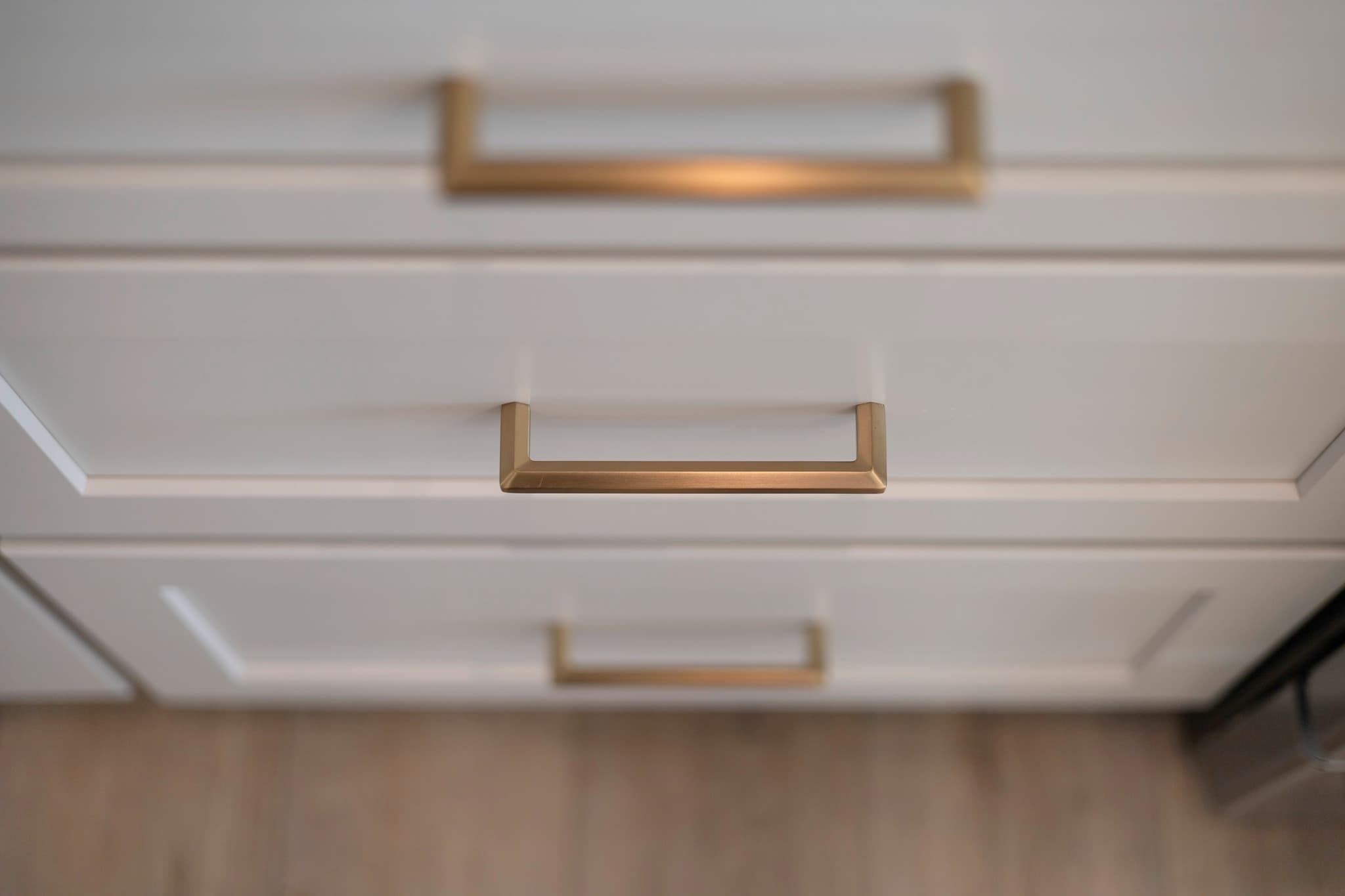 White shaker drawers with brushed brass cup pulls