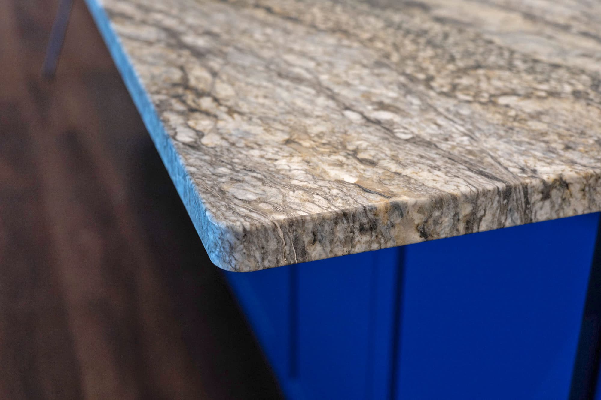 Granite countertop edge detail on bold blue kitchen island