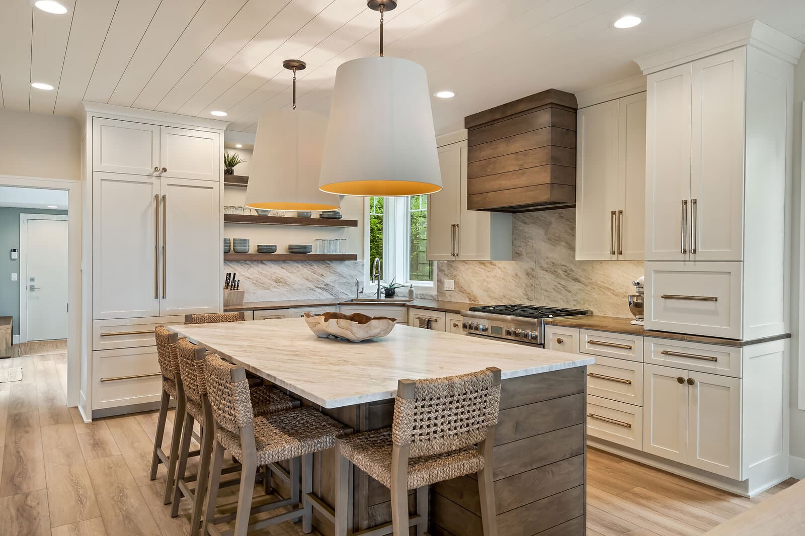 Coastal kitchen with oversized pendants and marble island