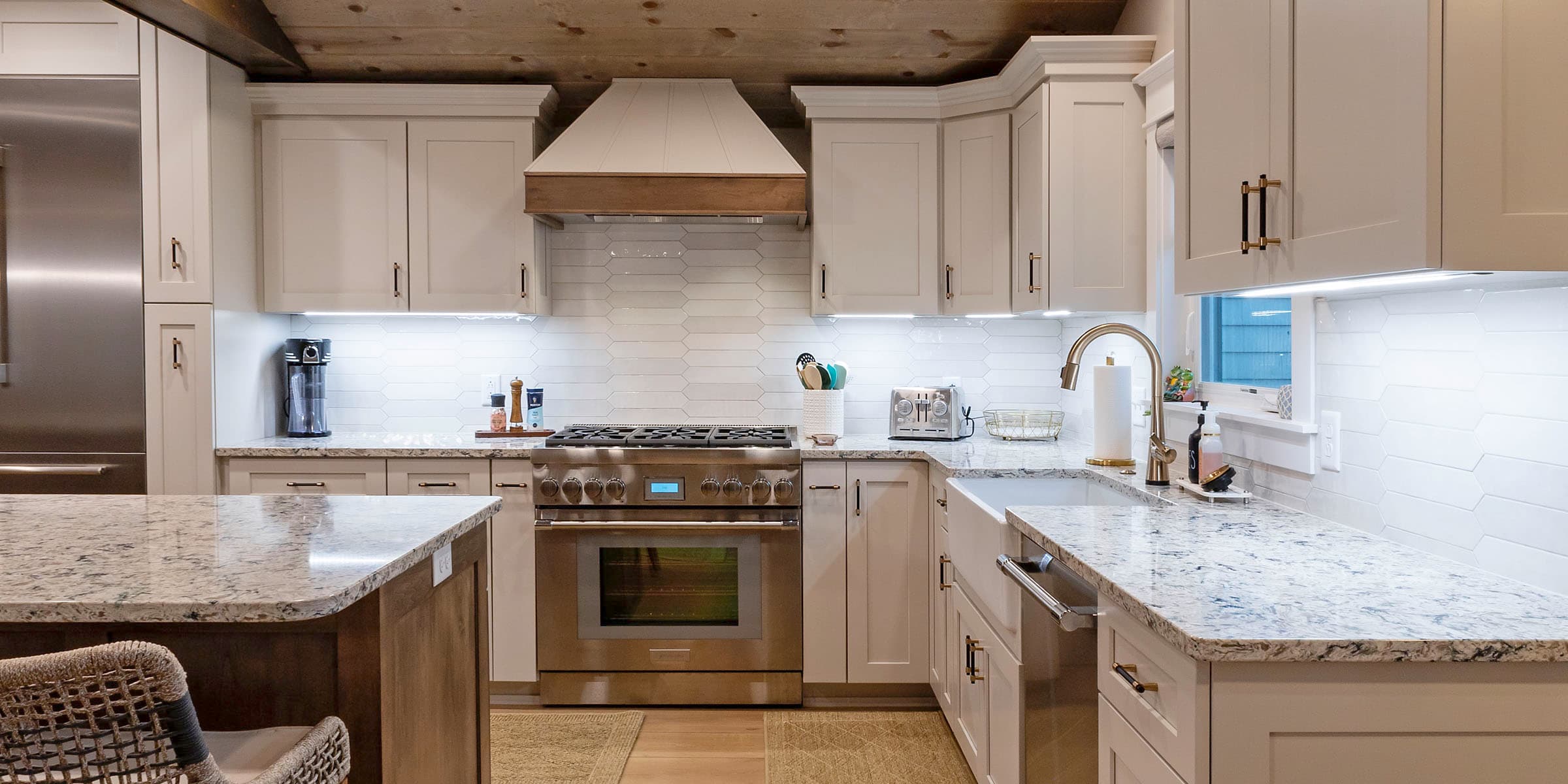 Farmhouse kitchen with wood beam ceiling, granite counters, and hexagonal backsplash