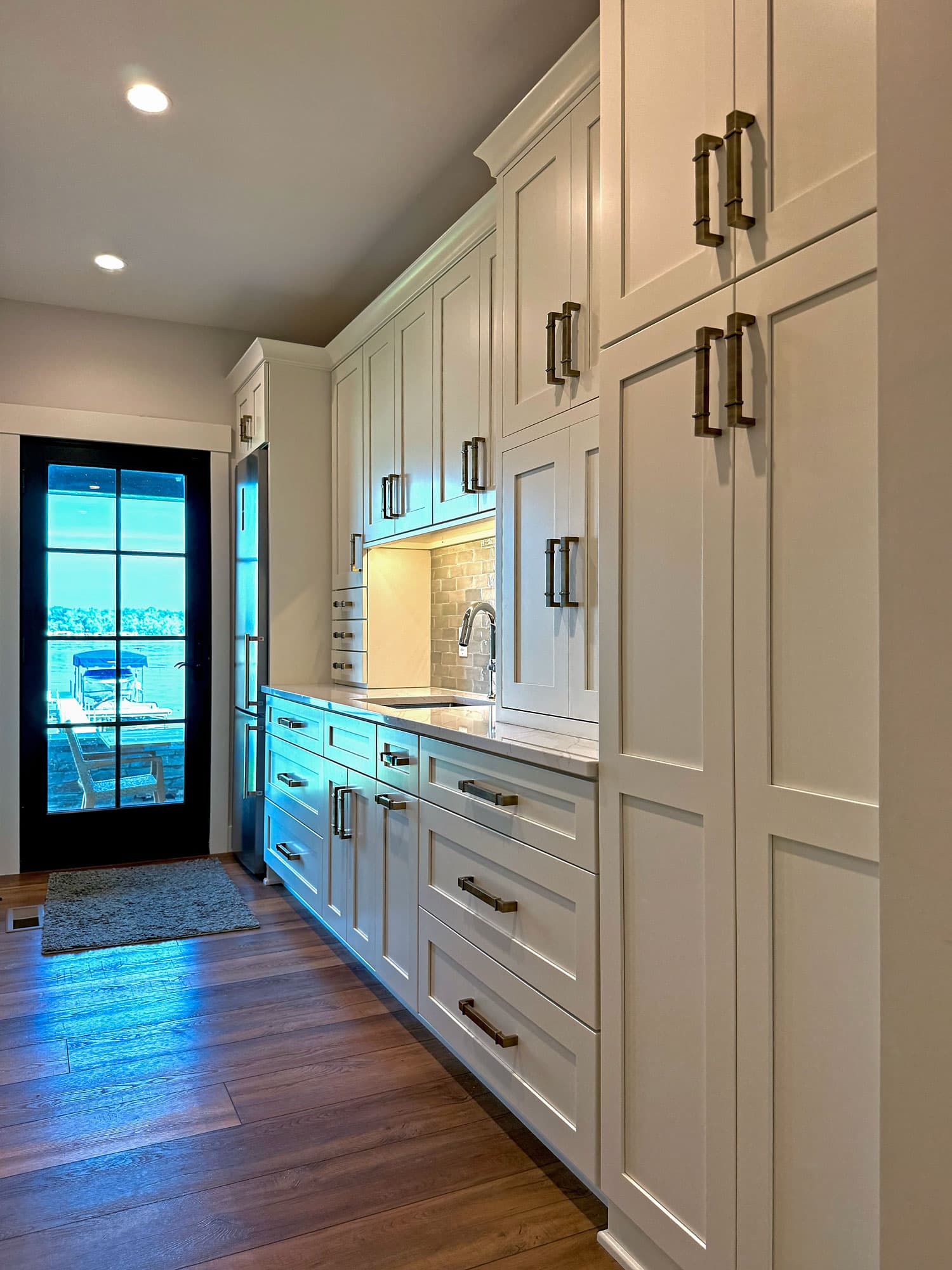 Kitchen with vaulted ceiling, loft balcony, and custom wood range hood